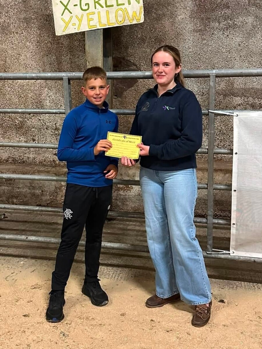 Junior third-place competitor Robbie Cox receives his certificate from Heather Millar.