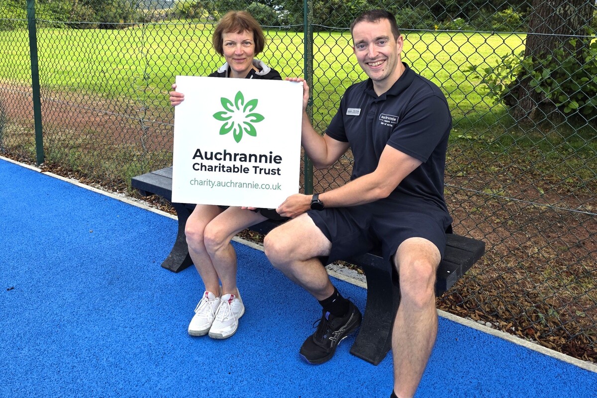 ACT trustee, Glen Sloss, with Maggie Carson, president of Brodick Tennis Club, on one of the new benches made possible by a grant. Photograph: ACT.