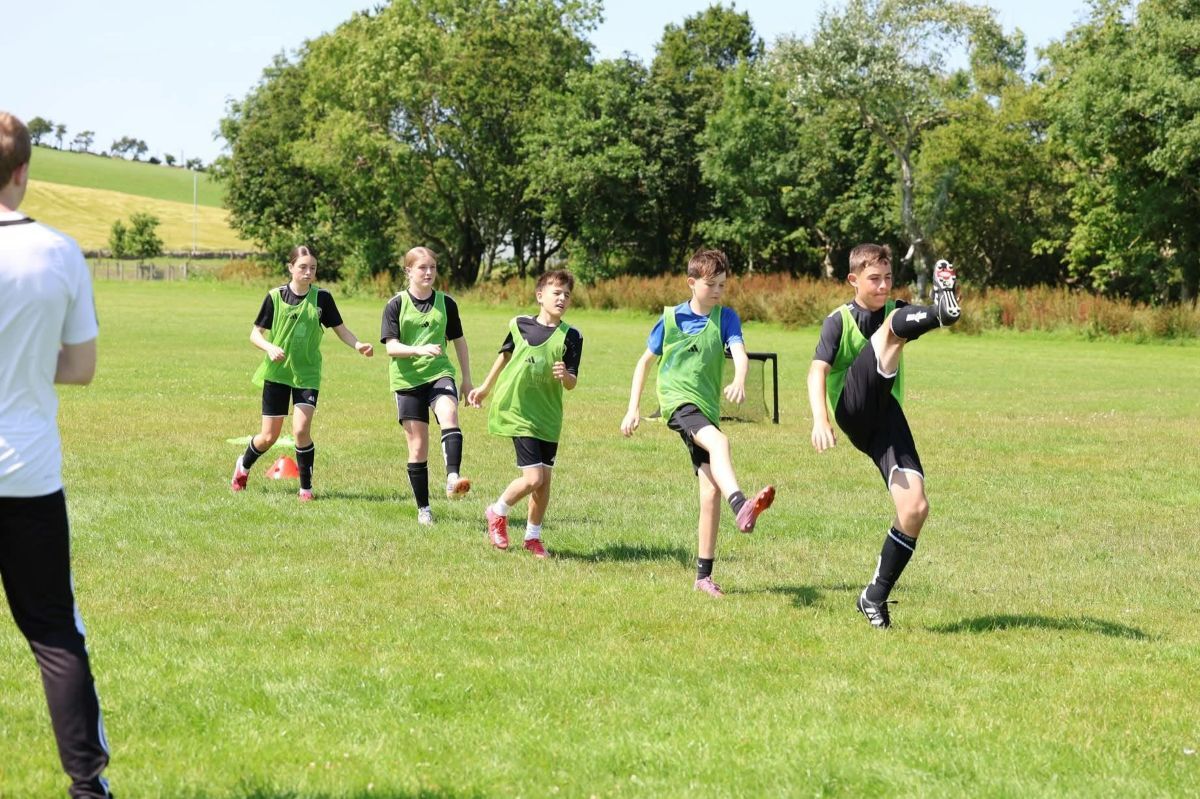 Camp participants take part in a football drill during the summer programme. Camp participants take part in a football drill during the summer programme.