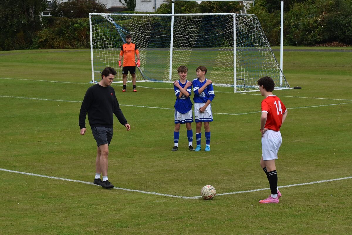 Two young Brodick players prepare to defend against a goal attempt by Shiskine.