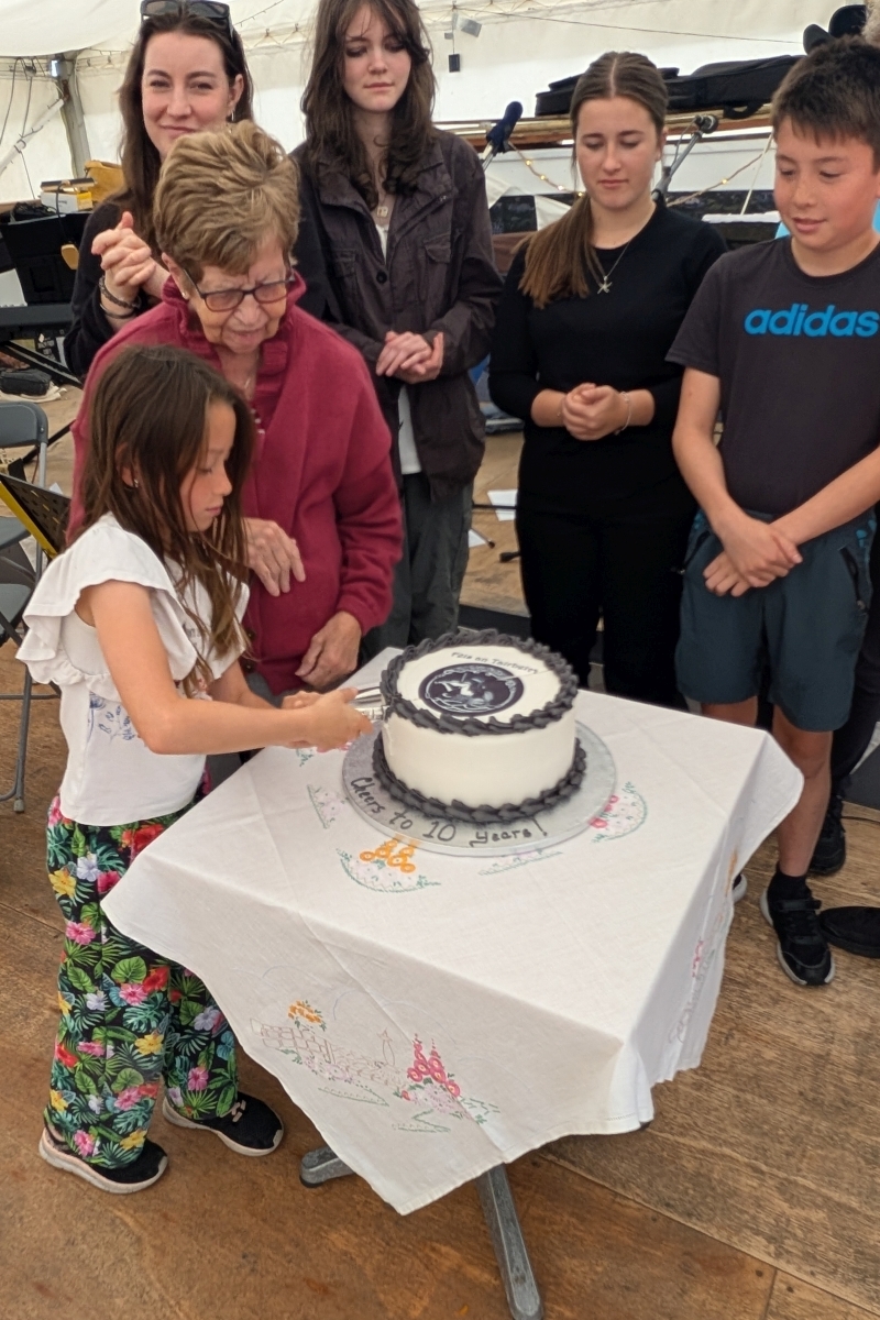 Councillor Anne Horn joined one of the youngest learners, Skye, to cut the birthday cake to get the party started. Photograph: Féis an Tairbeirt Councillor Anne Horn joined one of the youngest learners, Skye, to cut the birthday cake to get the party started. Photograph: Féis an Tairbeirt